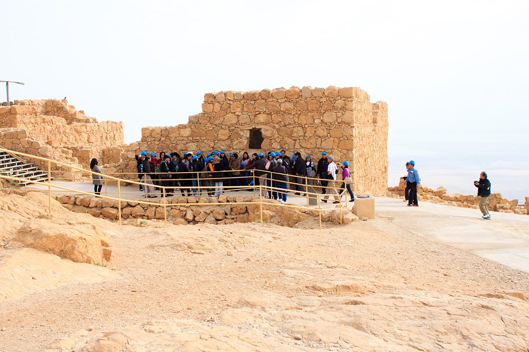 Азиатские туристы на пике горы Масада в Израиле